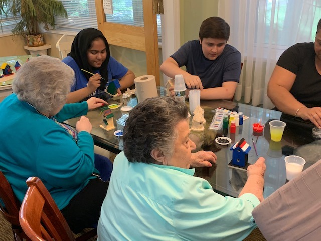 Two older women and two teens do crafts together